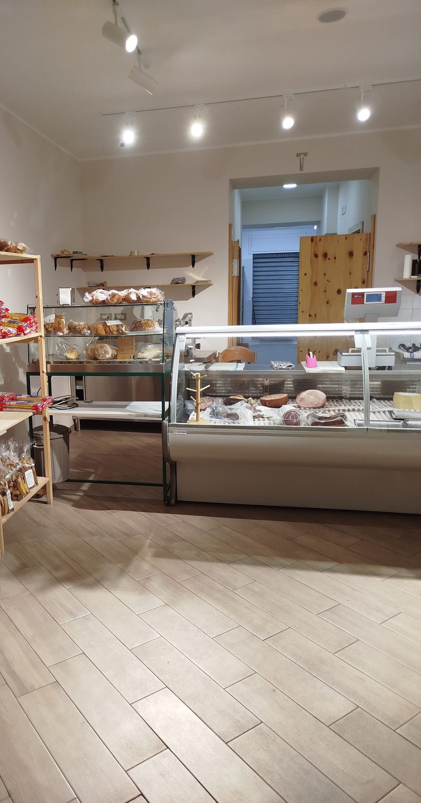 Interno del negozio, con scaffali e banco frigo.